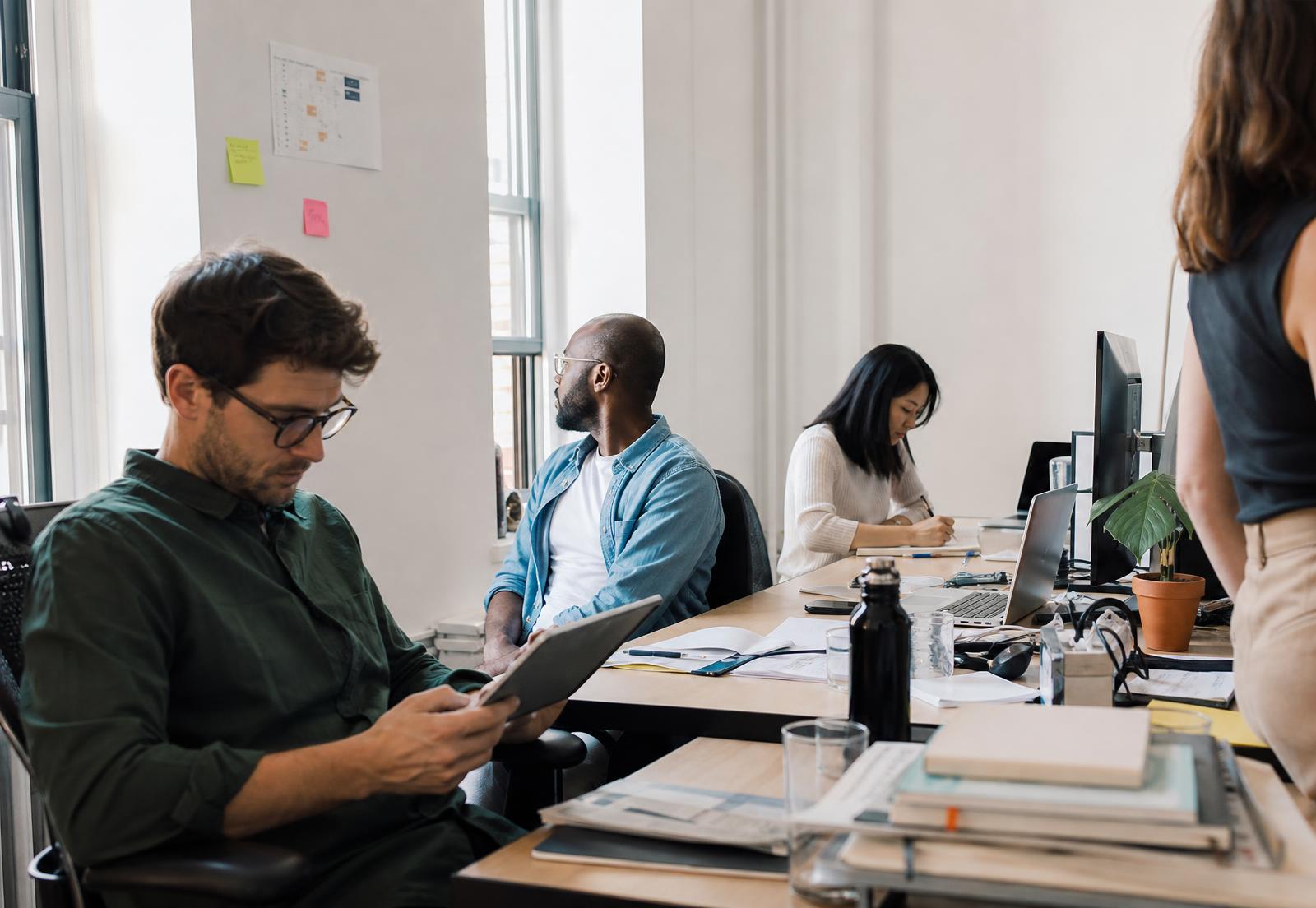 Four professionals working independently in a bright contemporary office
