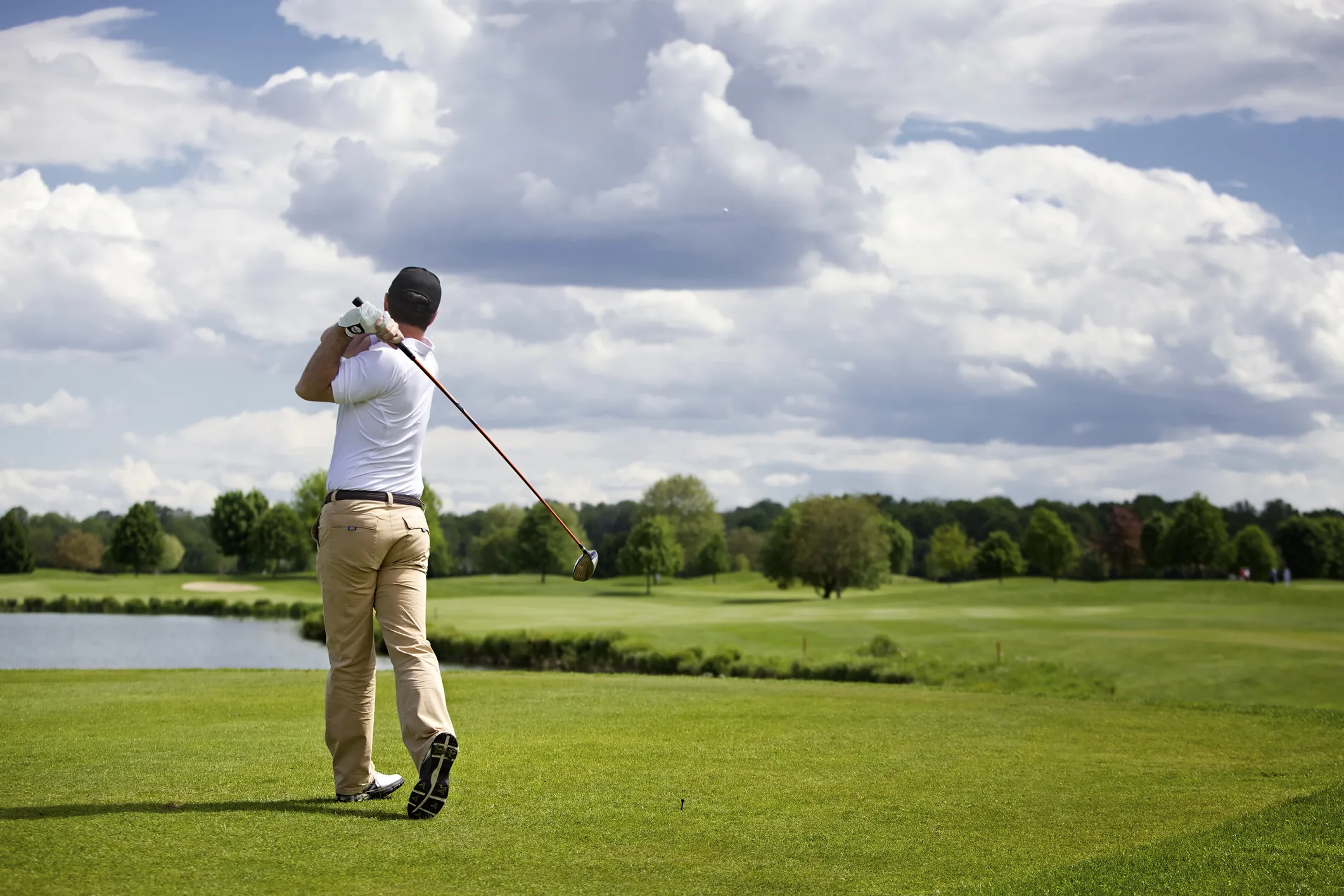 A man golfing on a course, illustrating the exclusive country club metaphor used to describe the OECD.