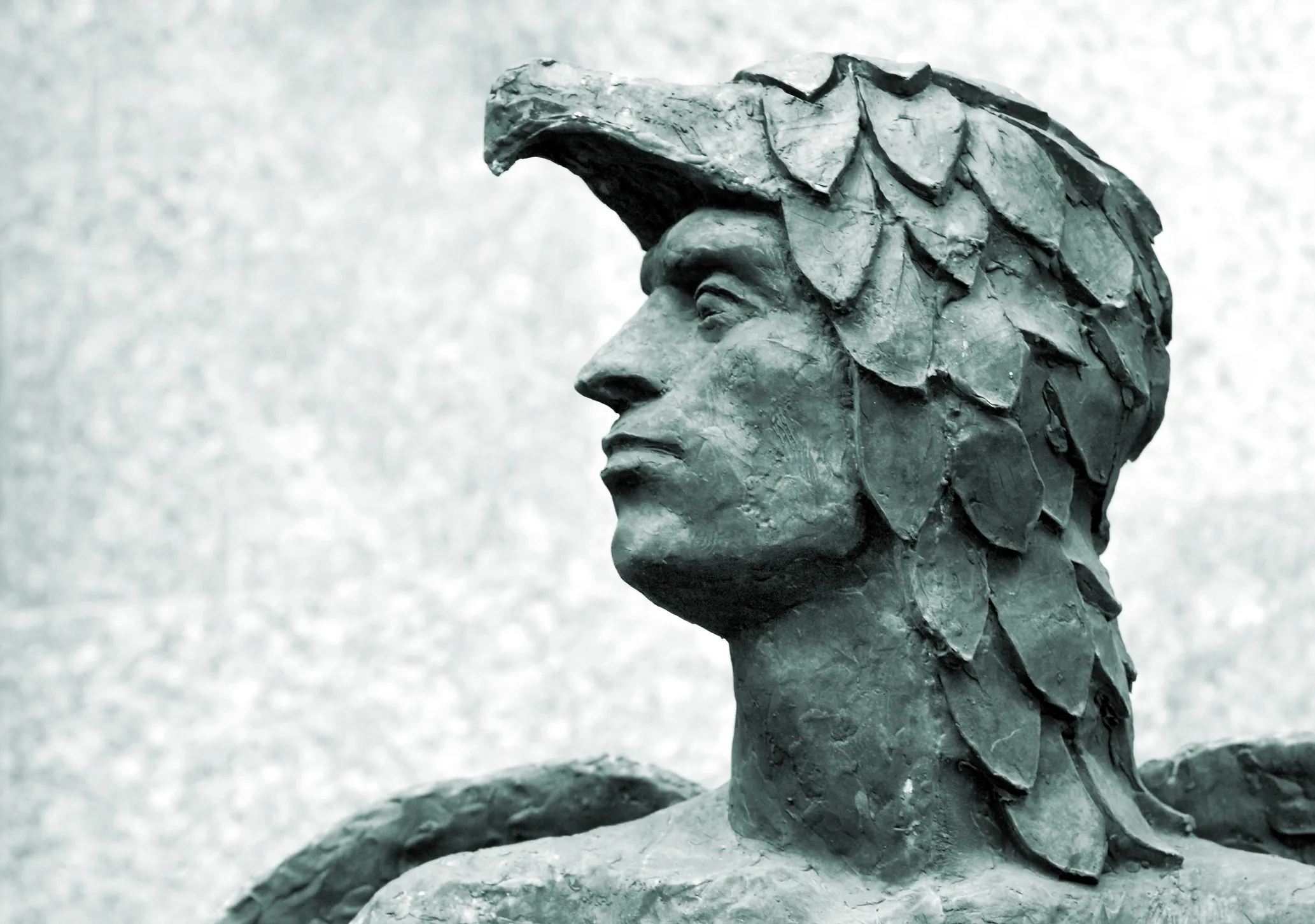 A stone statue of Icarus with a feathered headdress, representing a phoenix.