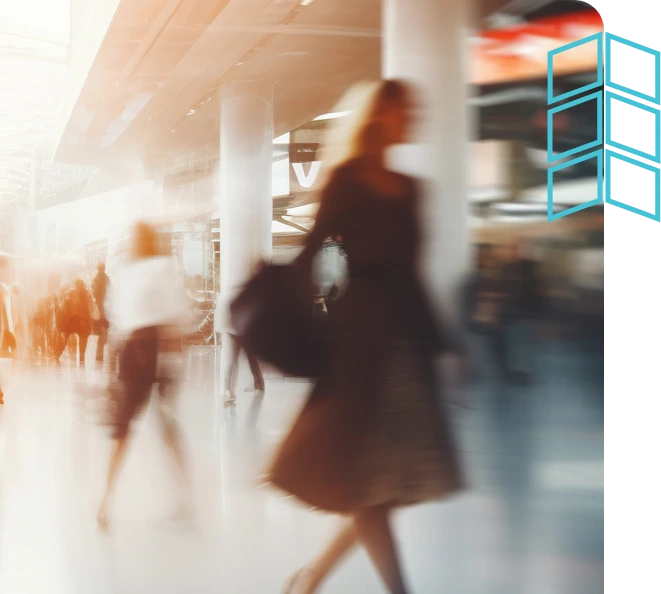 People moving quickly through a modern airport or public space, symbolizing a fast-paced world.