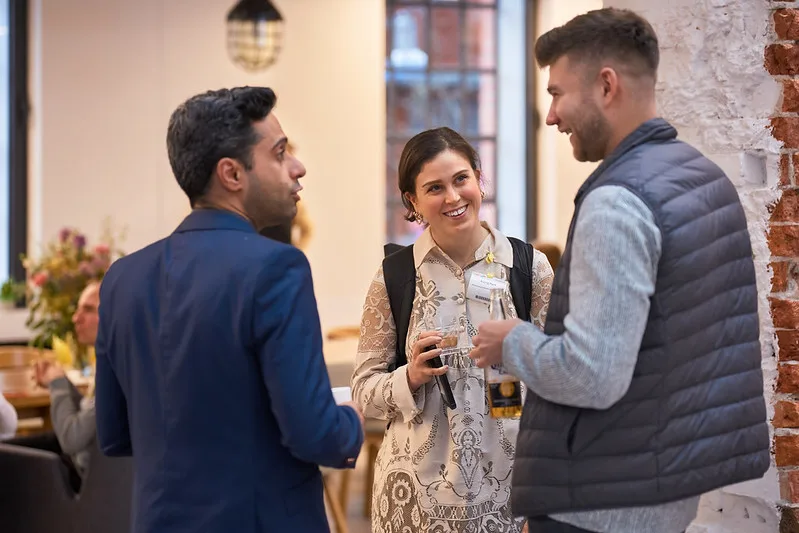 Group of professionals networking and collaborating at a tech ecosystem event.