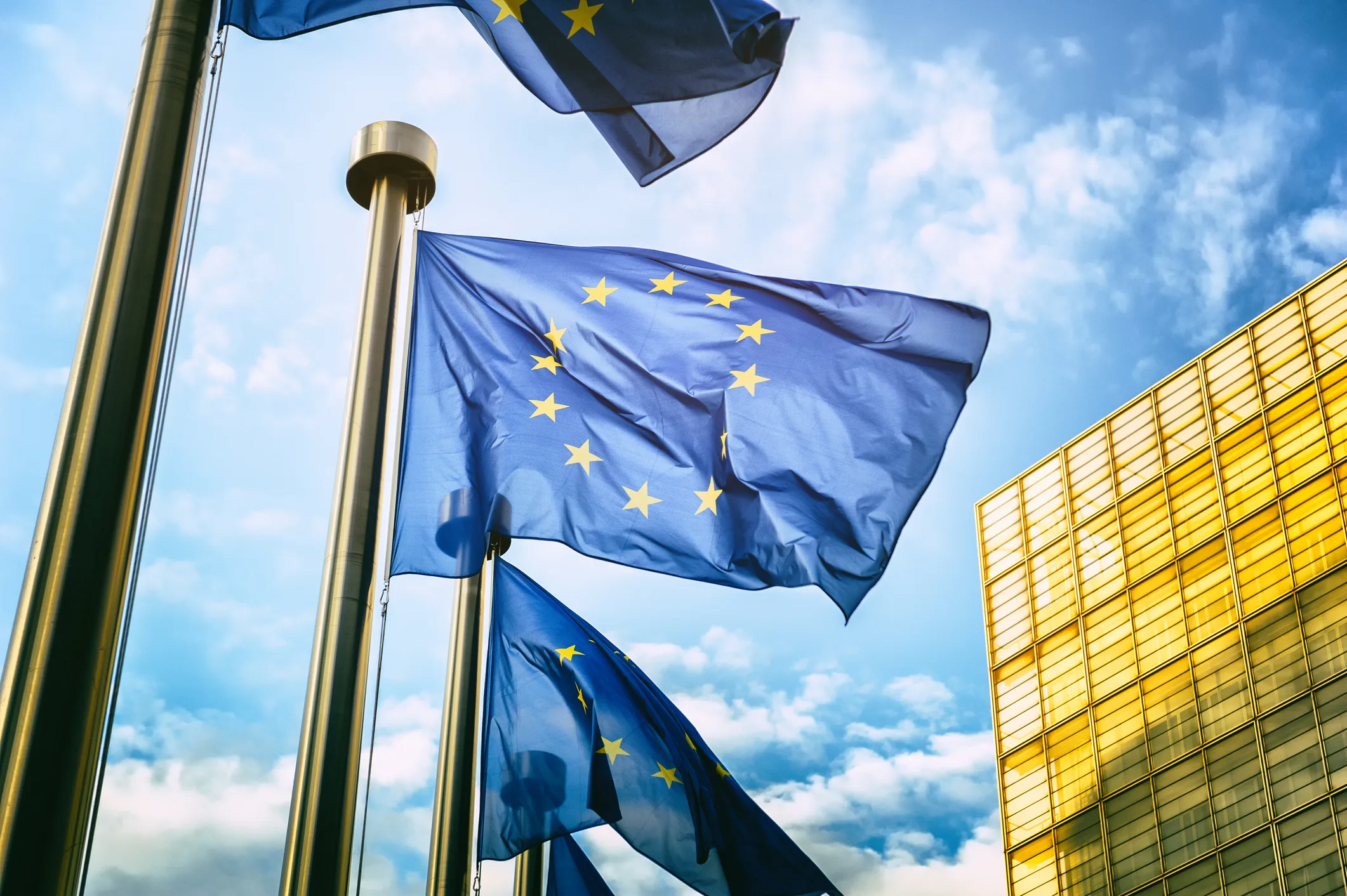 European Union flags waving outside a modern EU building, symbolizing Ukraine and Moldova’s ongoing pursuit of EU membership and European integration