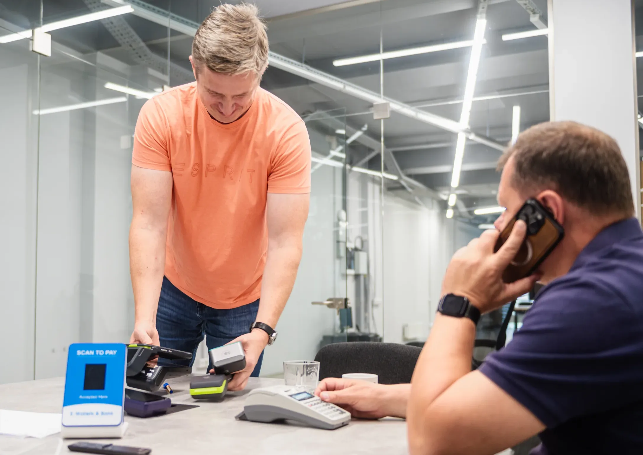 Moldovan fintech entrepreneurs testing contactless payment devices in an office, showcasing the rise of start-ups like Finergy driving instant payments innovation.