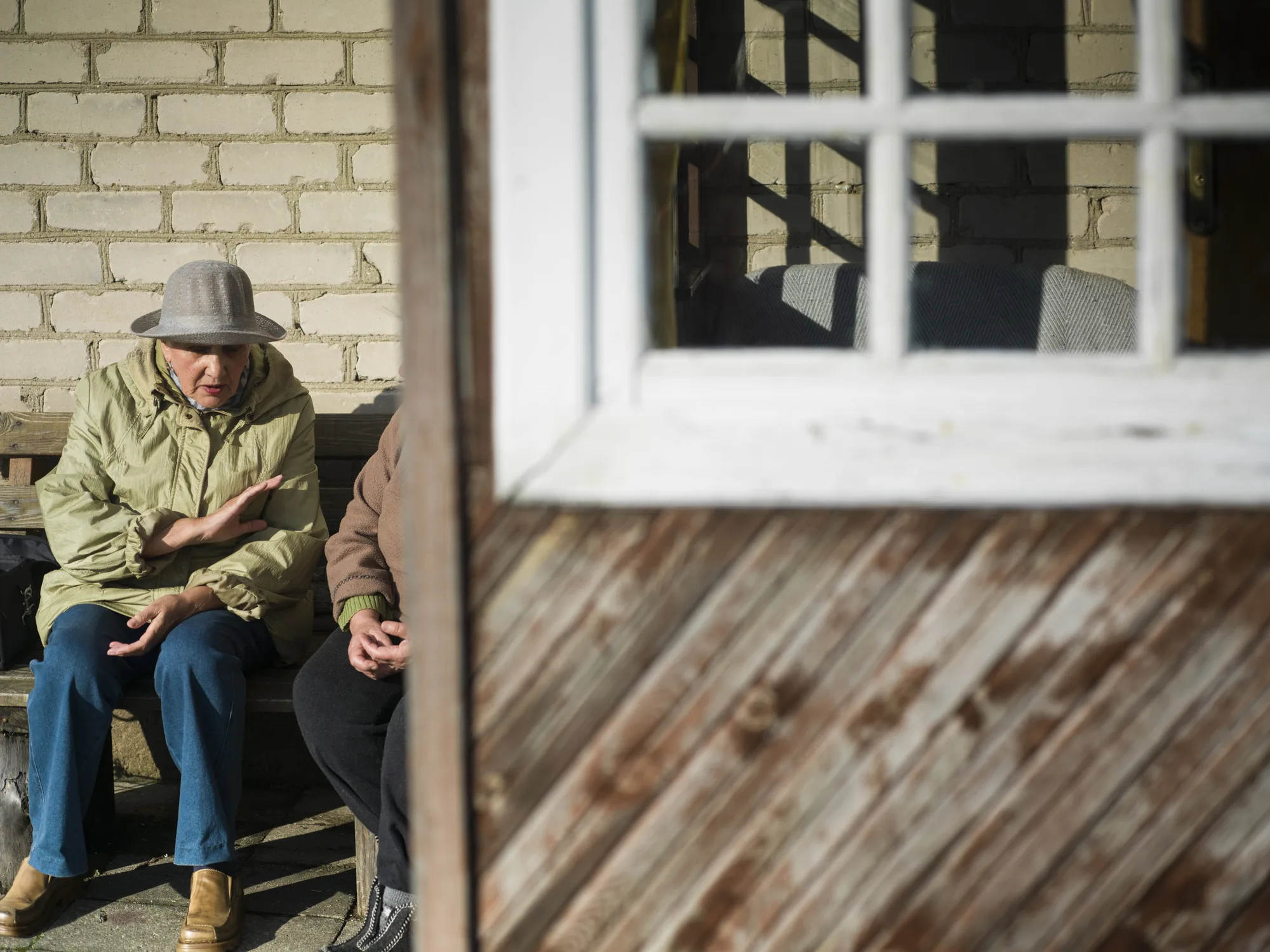 Elderly people sitting outside a rural home, symbolizing Europe’s ageing population and the urgent need to reform pension systems for sustainable retirement.