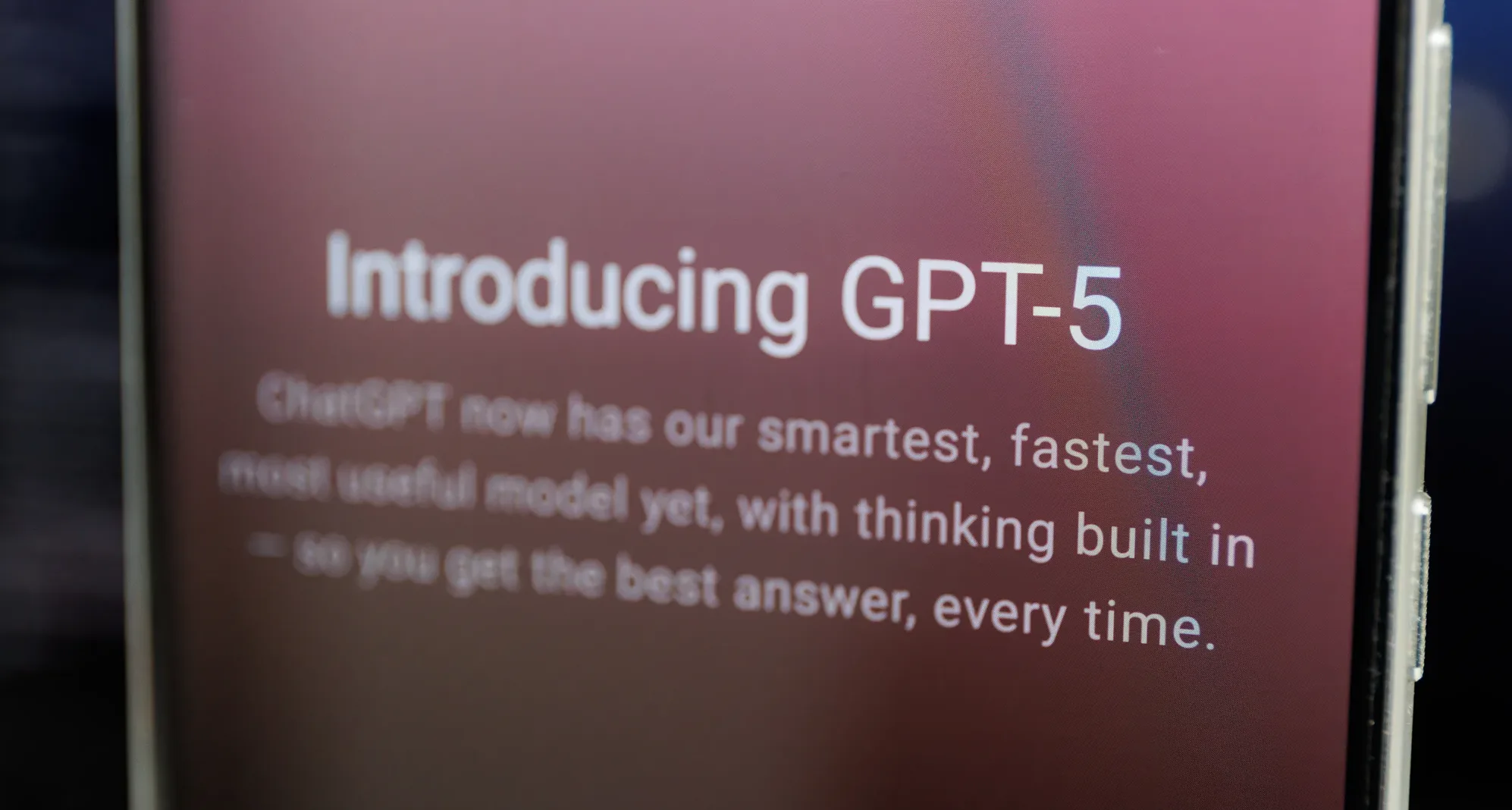 Close-up of a smartphone screen displaying ‘Introducing GPT-5’, symbolizing AI’s rapid advancement and the growing global divide in technology access.