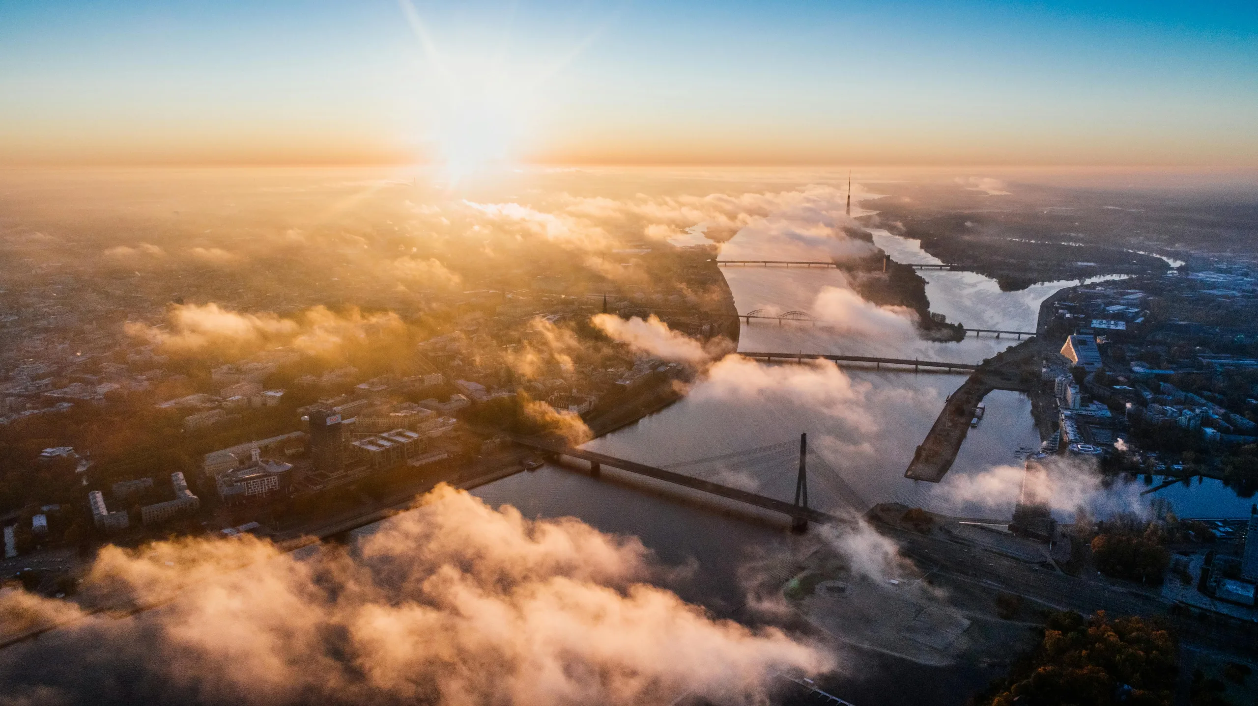 Aerial sunrise view over Riga with river bridges and clouds, symbolizing Latvia’s thriving start-up ecosystem and Baltic innovation.