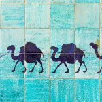 Silhouette of a camel caravan with a rider on blue tiles, symbolizing Uzbekistan’s trade routes, cultural heritage, and connection to the EU