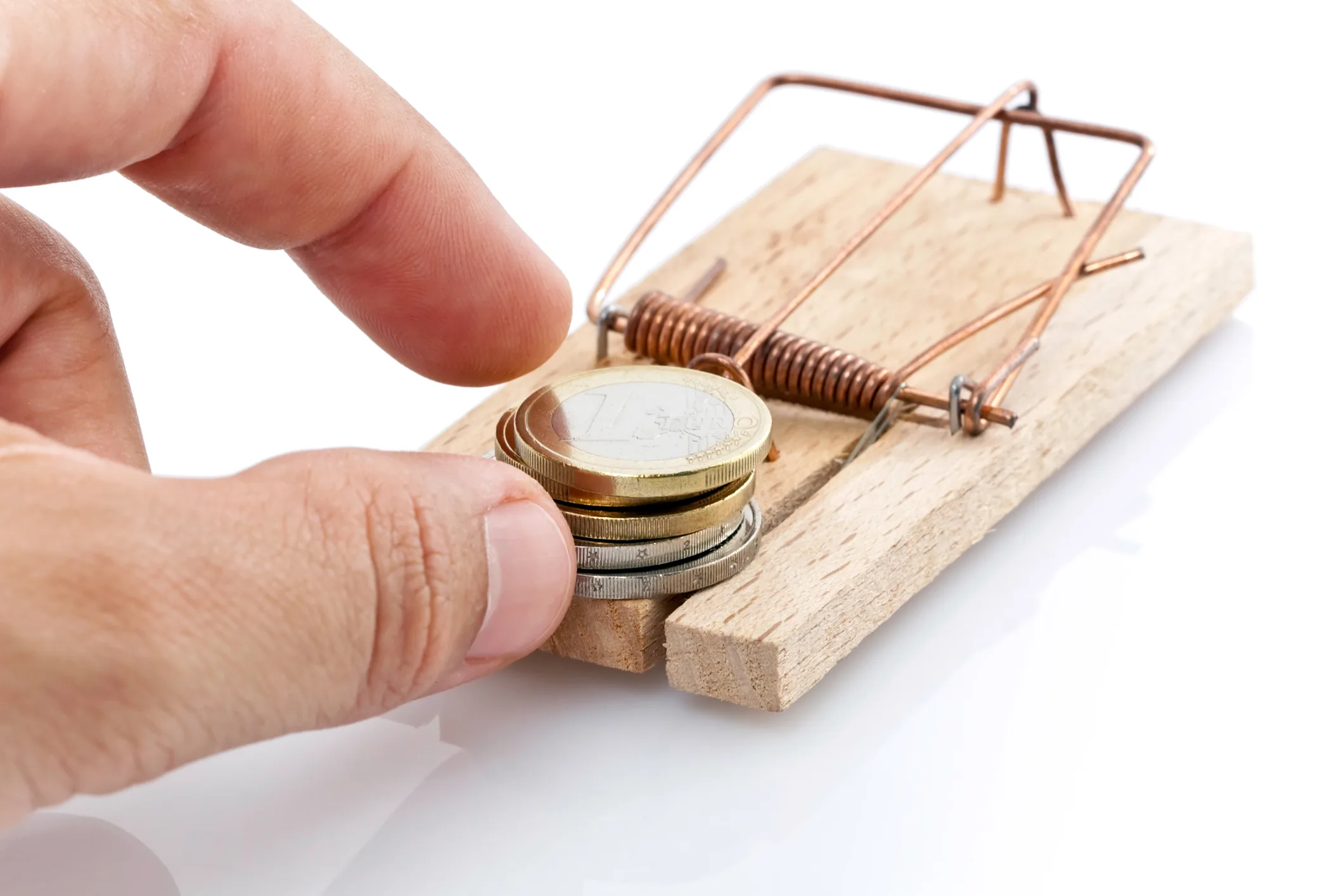 Hand reaching for euro coins placed on a mousetrap, symbolizing financial risk and the dangers of selling residence permits explored in “Fool’s Gold.”