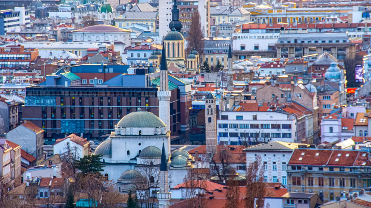 A panoramic view of Sarajevo’s historic skyline with Ottoman-era mosques, Austro-Hungarian buildings, and modern architecture.