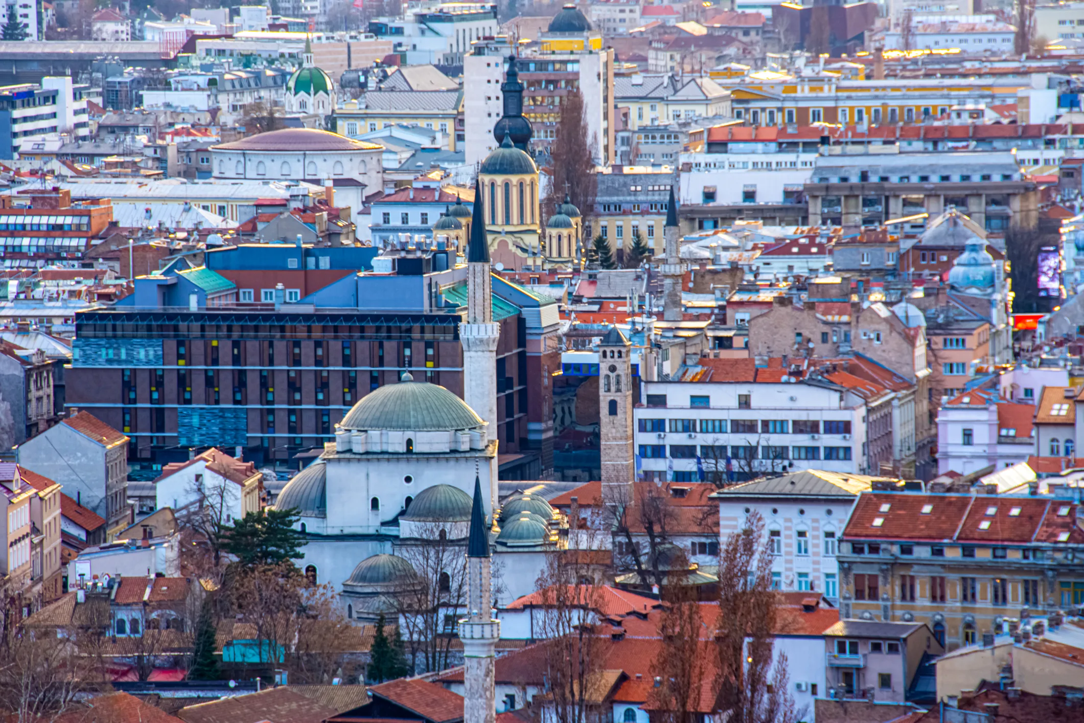 A panoramic view of Sarajevo’s historic skyline with Ottoman-era mosques, Austro-Hungarian buildings, and modern architecture.