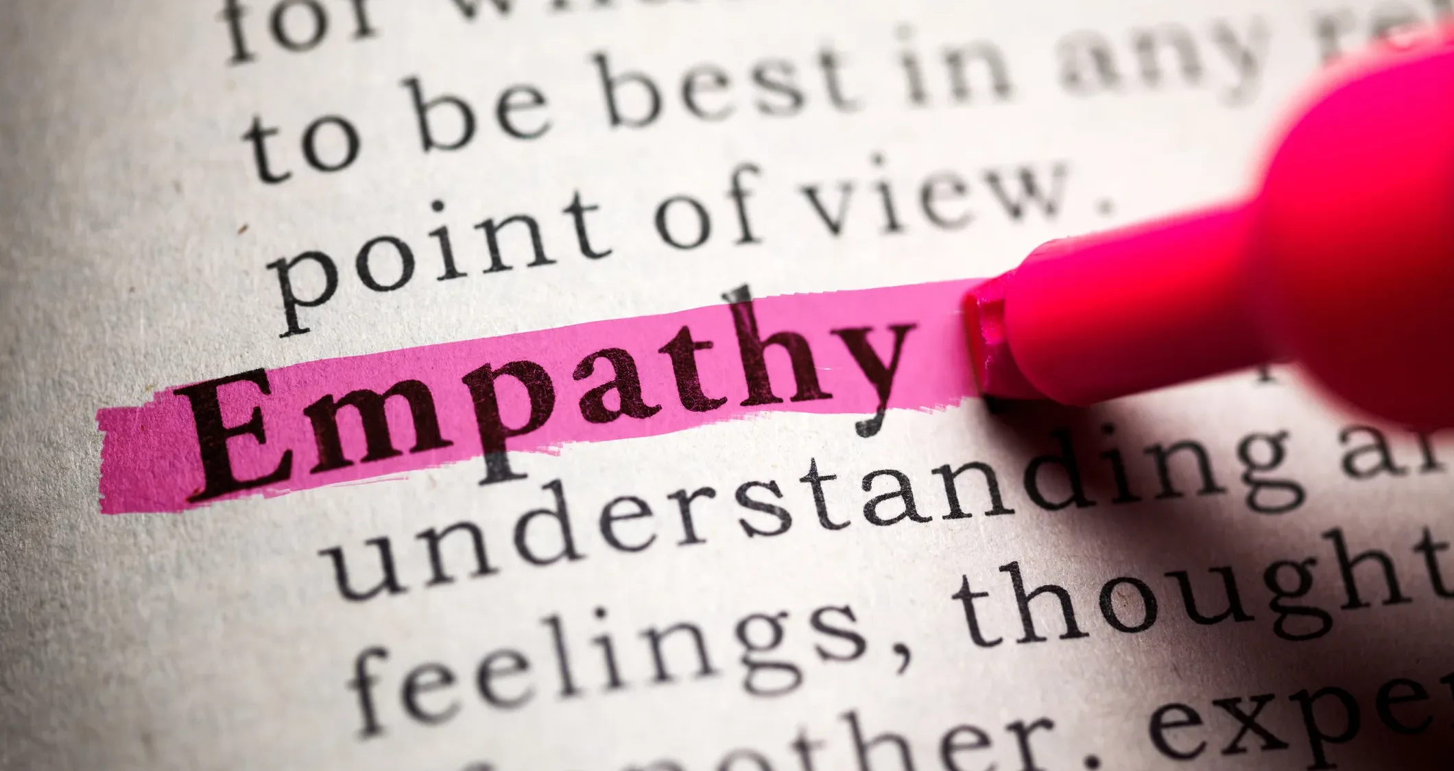 Word “Empathy” highlighted in pink marker on a dictionary page, symbolizing human connection and emotional intelligence in business and leadership.