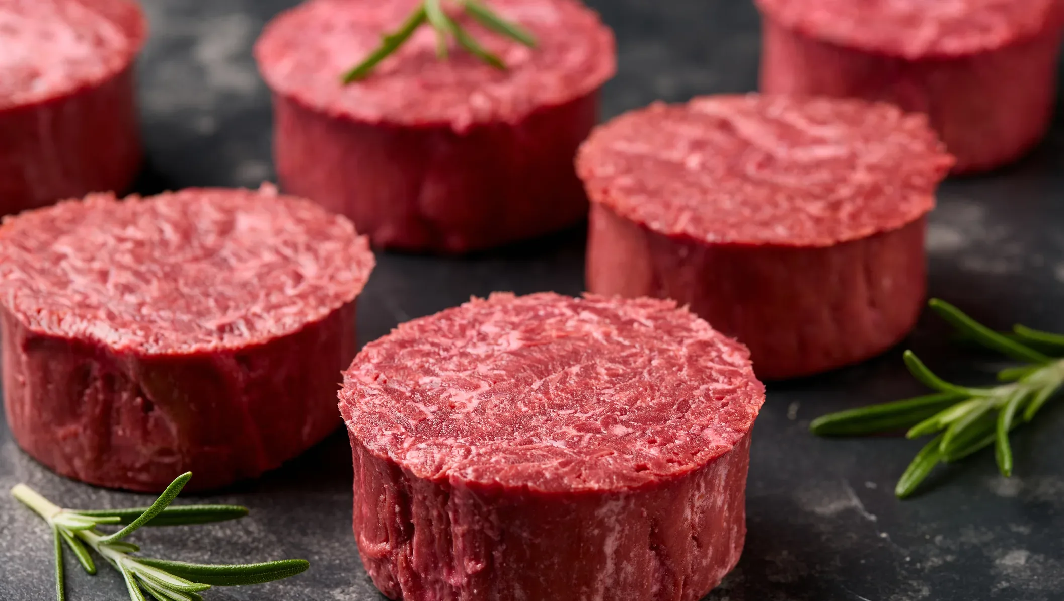 Plant-based fillet steaks on a dark surface with rosemary, symbolizing innovation in sustainable food and meat alternatives from “The Great Food Reinvention.”