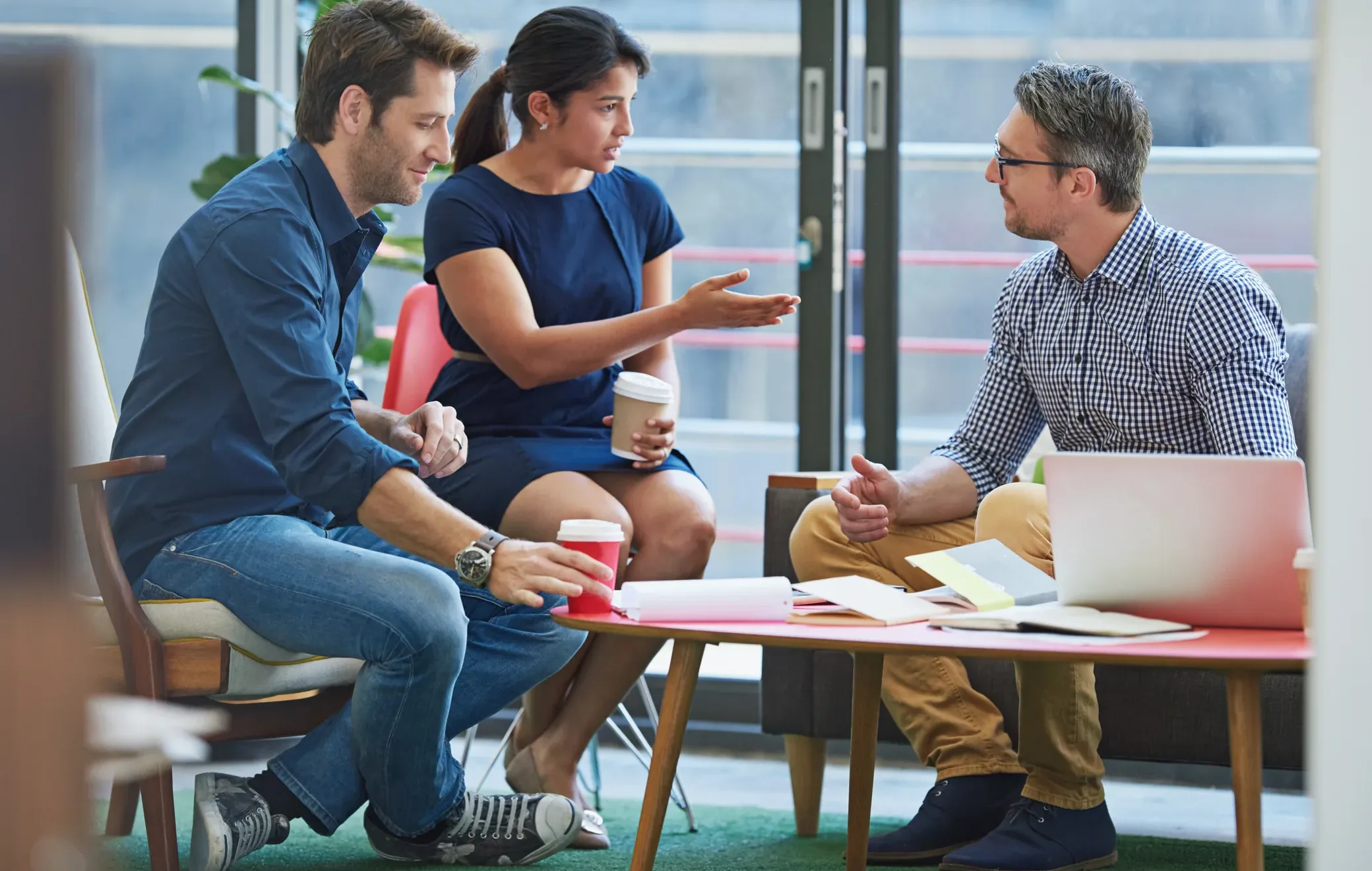 Business professionals discussing early-stage funding and startup traction in an informal office, illustrating the shift to “show, don’t tell.